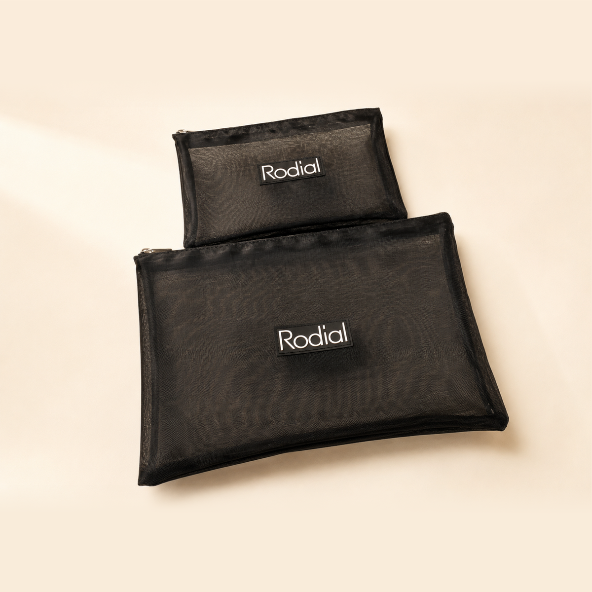 Two sizes of black RODIAL mesh cosmetic bags with branded logo patches and quality zippers